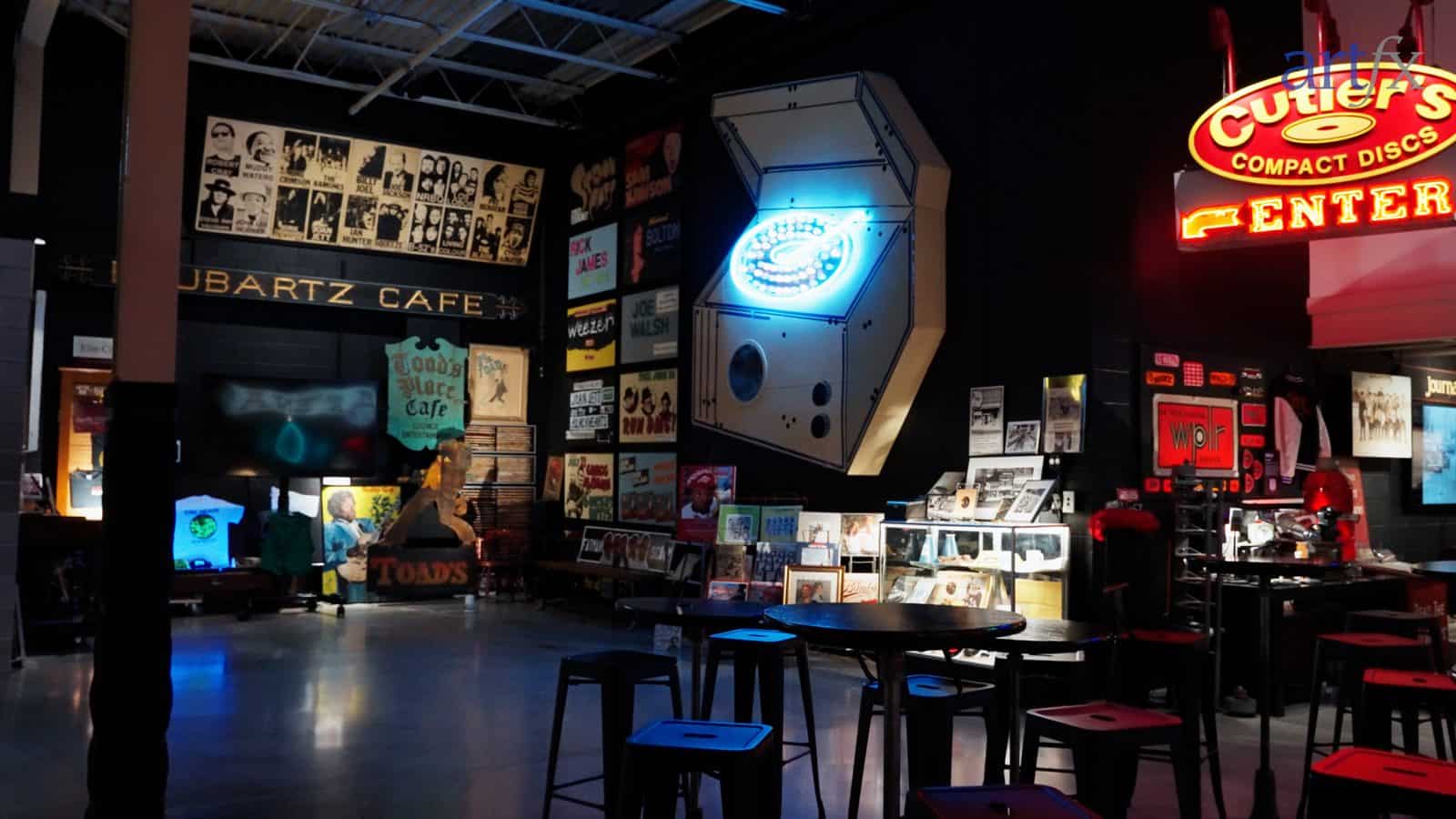 The illuminated Cutler's Compact Discs neon sign and a blue neon disc-player sculpture in the Rubartz Cafe area of the Lost in New Haven museum, restored by ARTfx